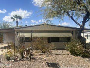 Charming single story home with desert landscaping, window awnings and a palm tree in the front yard at 2744 N Trevino Pl, Mesa, AZ 85215