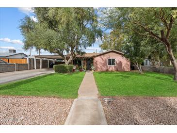 Charming single-story home featuring a well-manicured lawn and mature trees providing ample shade at 2942 E Mulberry Dr, Phoenix, AZ 85016