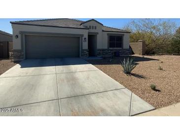 Charming single-story home featuring a low-maintenance desert landscape and a two-car garage at 29573 W Mitchell Ave, Buckeye, AZ 85396