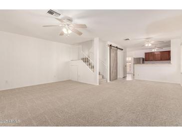 Spacious living room with neutral carpet, ceiling fans and staircase access to upper level at 5808 E Brown Rd # 110, Mesa, AZ 85205