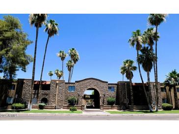 Charming apartment complex featuring desert landscaping with palm trees against a backdrop of clear blue skies at 7110 E Continental Dr # 1031, Scottsdale, AZ 85257