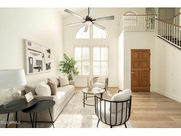 Bright living room with high ceilings, large windows, a ceiling fan, and modern furnishings at 9224 E Windrose Dr, Scottsdale, AZ 85260