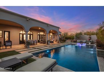 An inviting outdoor pool with waterfall feature, lounge chairs, and covered patio, perfect for relaxation and entertainment at 10040 E Happy Valley Rd # 289, Scottsdale, AZ 85255