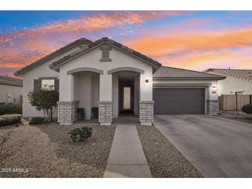 Charming single-story home boasts beautiful stone accents, well-maintained landscaping, and a two-car garage at 14317 W Faye Way, Surprise, AZ 85387