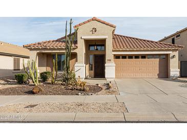 Charming home showcasing a well-manicured front yard with desert landscaping, a two-car garage, and a welcoming entrance at 17632 W Voltaire St, Surprise, AZ 85388