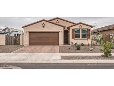 Charming single-story home featuring a two-car garage, desert landscaping, and a welcoming facade at 18625 W Williams Rd, Surprise, AZ 85387