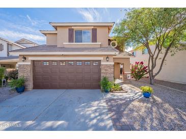 Charming two-story home featuring a two car garage, landscaping, and stone accents at 1899 W Prospector Way, San Tan Valley, AZ 85144