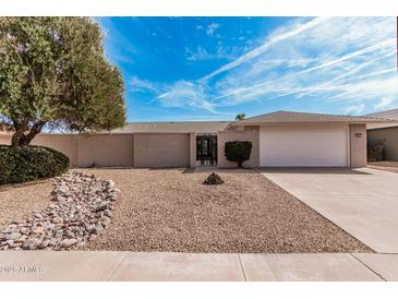 Charming single-story home featuring a low-maintenance front yard and attached two-car garage at 19817 N Ponderosa Cir, Sun City, AZ 85373