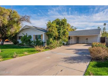 Charming single-story home with a spacious driveway, mature landscaping, and a well-maintained front yard at 2125 W Berridge Ln, Phoenix, AZ 85015