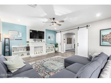 Inviting living room featuring a modern fireplace and stylish sliding barn doors at 23510 N 25Th St, Phoenix, AZ 85024