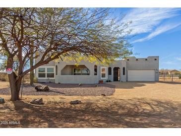 Stunning gray home featuring desert landscaping and a two-car garage at 28214 N 223Rd Ln, Wittmann, AZ 85361