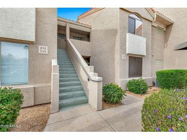 Charming building exterior with landscaped grounds and convenient stair access to upper-level units at 5249 E Shea Blvd # 214, Scottsdale, AZ 85254