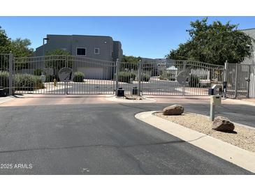 Secured entrance with decorative iron gates for a private community, and desert landscaping at 5400 S Hardy Dr # 110, Tempe, AZ 85283