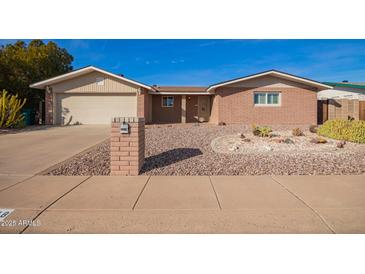 Charming single-story brick home featuring desert landscaping, attached garage, and covered entrance at 5618 E Des Moines St, Mesa, AZ 85205