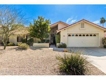 Charming single-story home with desert landscaping, two-car garage, and a red tile roof in a sunny neighborhood at 817 E Meadow Ln, Phoenix, AZ 85022