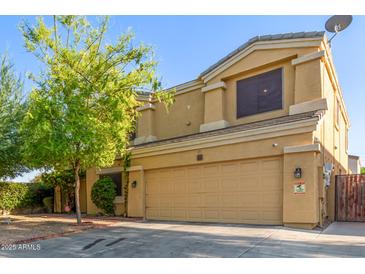 Two-story stucco home with a two-car garage and mature landscaping, offering curb appeal at 8305 W Pioneer St, Tolleson, AZ 85353