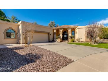 Beautiful single-story home with a well-manicured lawn, desert landscaping, and a spacious driveway at 9214 N 83Rd St, Scottsdale, AZ 85258