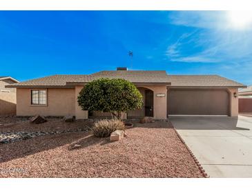 Single level home showcasing desert landscaping, a two car garage, and a front entrance with gate at 9283 W Rafael Dr, Arizona City, AZ 85123