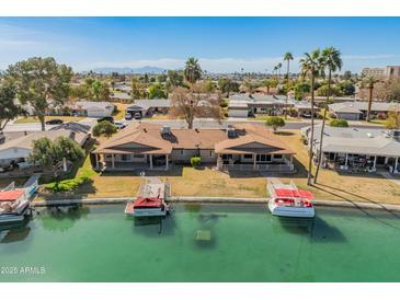 Aerial view of the home and surrounding neighborhood along a waterway at 10116 W Bolivar Dr, Sun City, AZ 85351