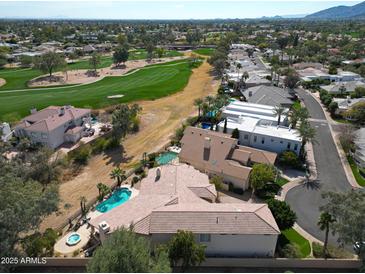 Expansive aerial view of a luxury home with a pool, golf course access, and desert landscaping at 10125 N 78Th Pl, Scottsdale, AZ 85258