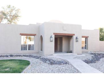 Charming Southwestern-style home featuring desert landscaping, a covered entry, and decorative wooden accents at 2113 E Glencove St, Mesa, AZ 85213