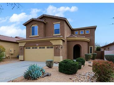 Two-story home with neutral stucco, arched entry, desert landscaping, and a two-car garage at 2527 W Amber Sun Dr, Phoenix, AZ 85085