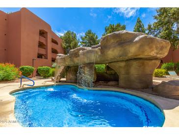 Inviting pool with rock waterfall feature offering a refreshing and unique outdoor amenity at 4303 E Cactus Rd # 408, Phoenix, AZ 85032