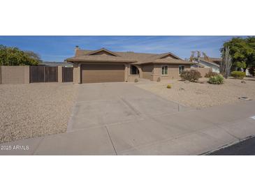 Charming single-story home featuring a two car garage and low maintenance desert landscaping at 6010 E Greenway Ln, Scottsdale, AZ 85254