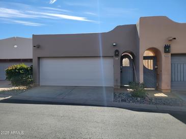 Charming Southwestern-style home featuring a two-car garage and arched entryway to a private courtyard at 6411 S River Dr # 53, Tempe, AZ 85283