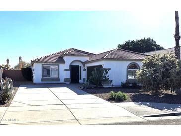 Charming single-story home featuring desert landscaping and a spacious driveway with a brown tile roof at 7903 E Harmony Ave, Mesa, AZ 85209