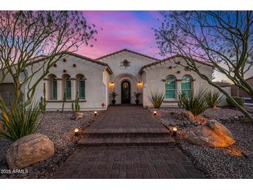 Charming home featuring a desert landscape and lit walkway, perfect for evening strolls, and beautiful desert sunset at 9183 W Foothill Dr, Peoria, AZ 85383