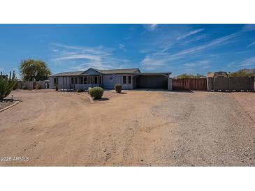 Charming single-story home featuring a large yard, carport, and desert landscaping at 1612 N 201St Ave, Buckeye, AZ 85396