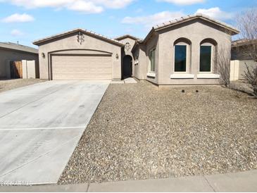 Charming single-story home featuring a well-kept yard, wide driveway, and an attached two-car garage at 16472 W Tether Trl, Surprise, AZ 85387