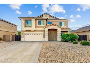 Two-story home with a two-car garage, desert landscaping, and a covered front porch at 16585 W Harrison St, Goodyear, AZ 85338