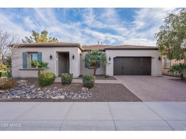 Charming single-story home featuring desert landscaping, a brick driveway, and a two-car garage at 1697 E Tangelo Pl, Queen Creek, AZ 85140