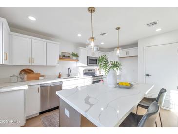 Bright kitchen with stainless steel appliances, quartz countertops and island with pendant lighting at 18811 N 19Th Ave # 2025, Phoenix, AZ 85027