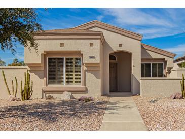 Charming single-story home with desert landscaping and neutral color palette under a sunny, blue sky at 19802 N Greenview Dr, Sun City West, AZ 85375