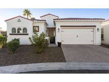 Charming single-Gathering home showcasing a well-manicured front yard, two-car garage, and desert landscaping at 2777 W Queen Creek Rd # 13, Chandler, AZ 85248