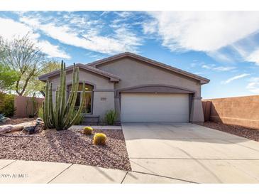 Charming single-story home with desert landscaping, beautiful cactus, and a two-car garage at 41401 N Maidstone Ct, Anthem, AZ 85086