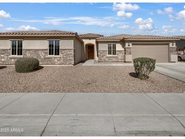 Charming single-story home featuring stone accents, a tile roof, and a well-manicured front yard at 5822 W Huntington Dr, Laveen, AZ 85339