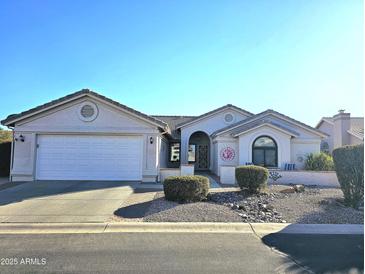 Charming single-story home with a well-manicured front yard and attached two car garage at 9047 E Cedar Waxwing Dr, Sun Lakes, AZ 85248