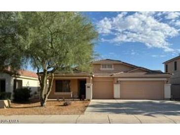 Charming single-story home with a three-car garage and well-manicured front yard at 36452 W Velazquez Dr, Maricopa, AZ 85138