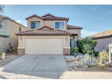 Charming two-story home with a well-manicured front yard and a two-car garage at 42015 W Hillman Dr, Maricopa, AZ 85138