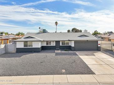 Charming single-story home featuring a spacious front yard with desert landscaping and a two-car garage at 6123 W Karen Lee Ln, Glendale, AZ 85306