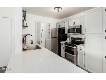 Bright kitchen with quartz countertops, stainless steel appliances, and white subway tile backsplash at 623 W Guadalupe Rd # 228, Mesa, AZ 85210