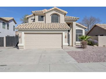 Inviting home showcasing a two-car garage, desert landscaping, and a neutral color palette at 7420 W Los Gatos Dr, Glendale, AZ 85310