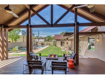 Inviting backyard patio features an outdoor lounge area with fire pit and a sparkling swimming pool in the manicured lawn at 130 W Palm Ln, Phoenix, AZ 85003