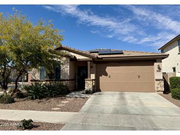 Charming single-story home featuring a two-car garage, desert landscaping, and solar panels at 14296 W Surrey Dr, Surprise, AZ 85379