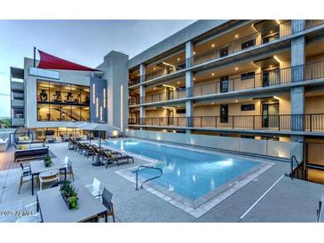 Stunning view of the swimming pool with lounge chairs and an amazing building in the background at 2300 E Campbell Ave # 204, Phoenix, AZ 85016