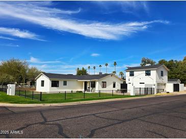 Charming updated house with a well-manicured lawn and black decorative fence at 2946 E Flower St, Phoenix, AZ 85016